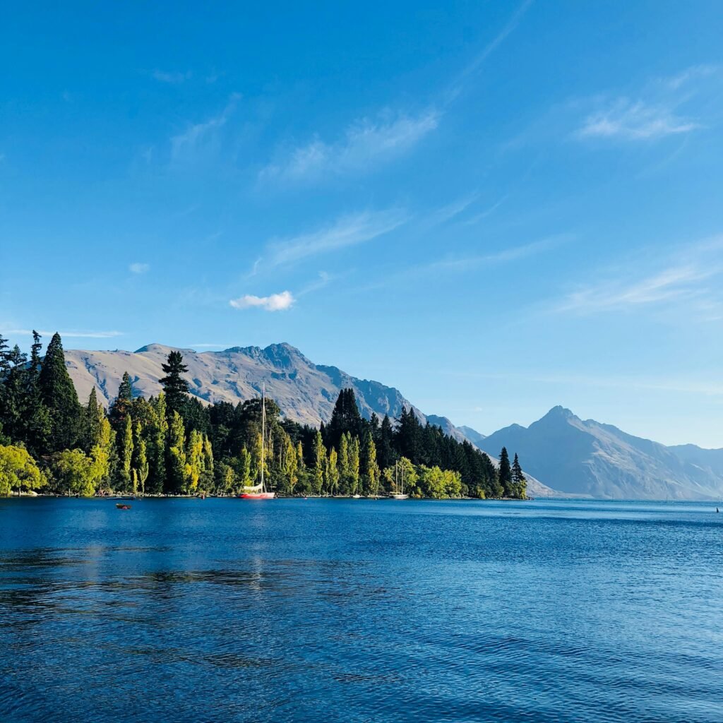 Stunning view of Lake Wakatipu with mountains and lush trees, perfect for nature lovers.