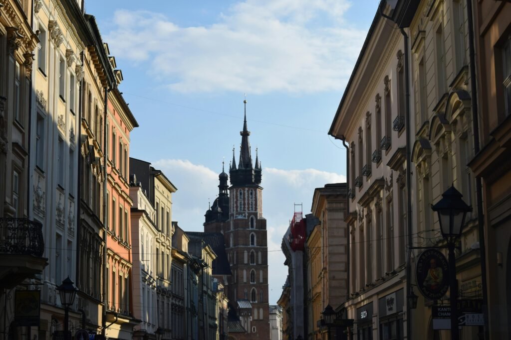 Charming Krakow street with St. Mary's Basilica, capturing historic architecture under a bright sky.