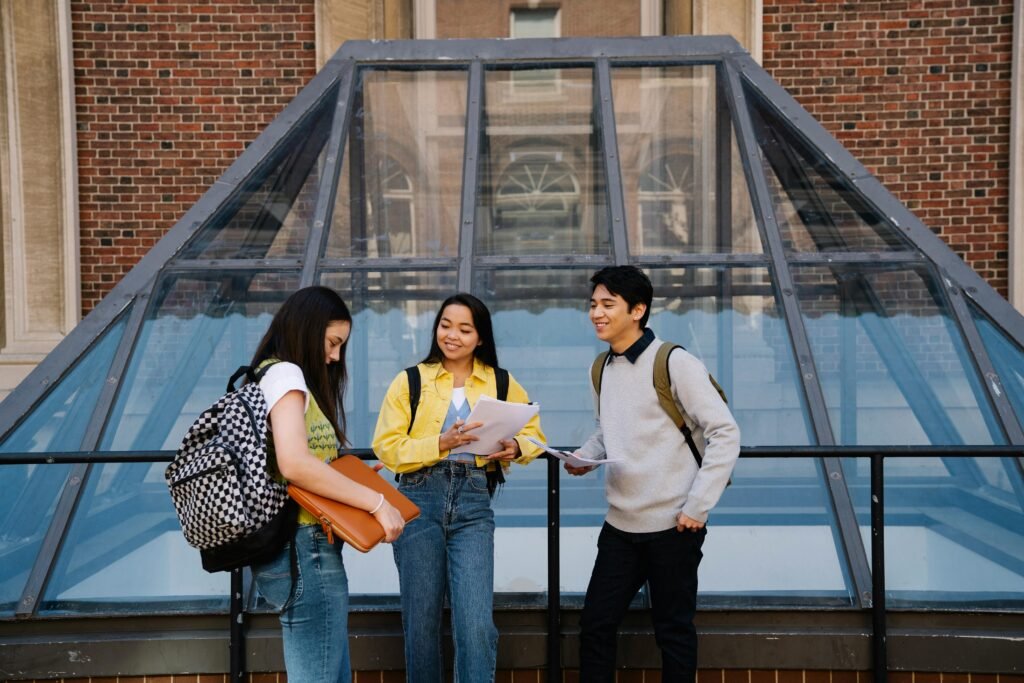 Students talking and studying together at a university campus outdoors.